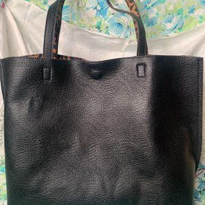Simple black faux leather bag with a cheetah lining and attached zipper pouch